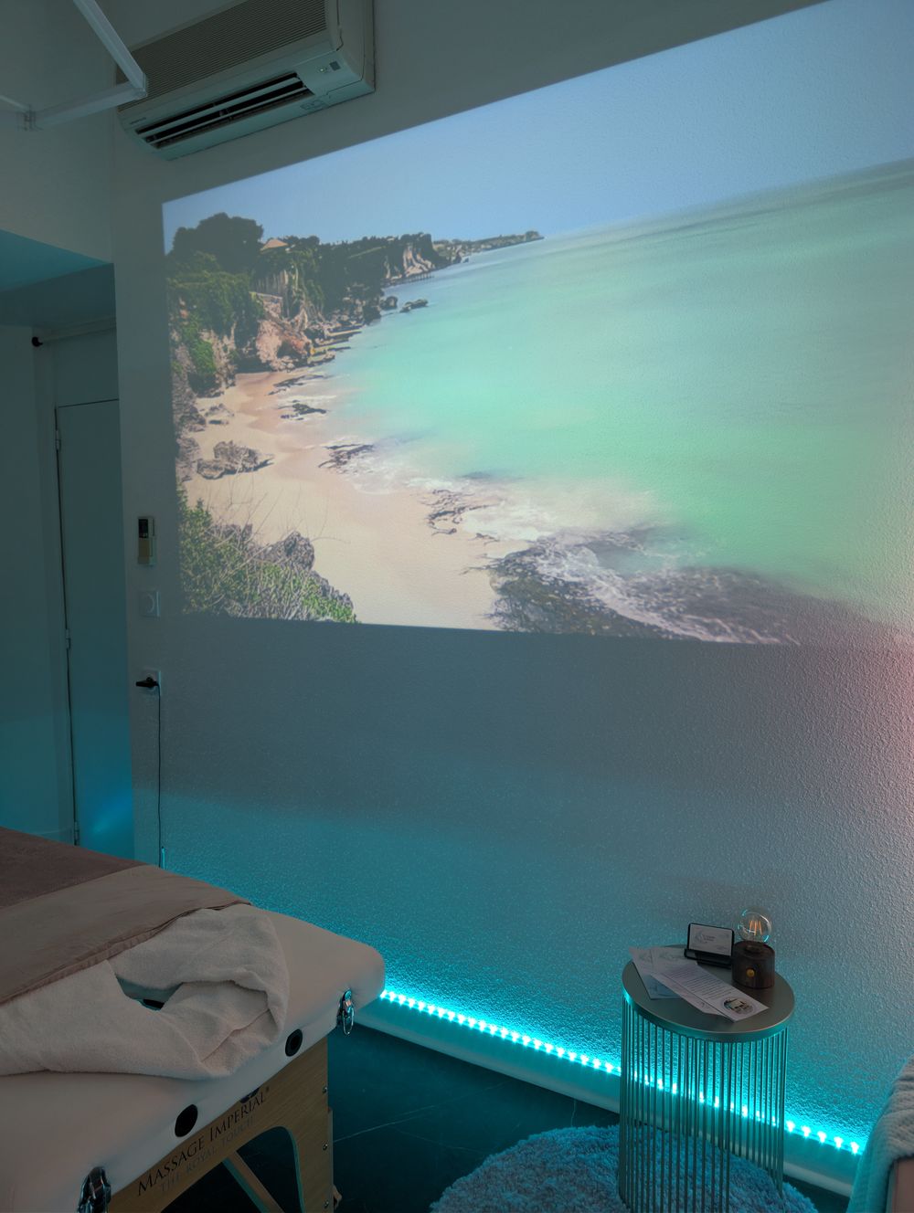 Escale à Bali : la salle de massage, avec une plage de Bali projetée sur le mur